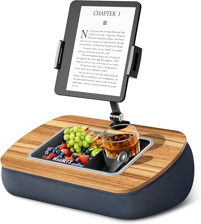 A gray, soft pillow stand holding a Kindle e-reader upright.